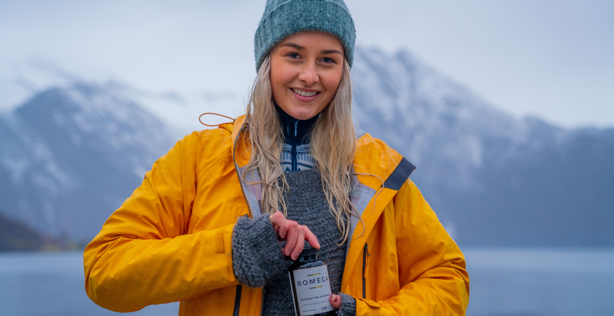 Smilende kvinne med omega-3 kosttilskudd